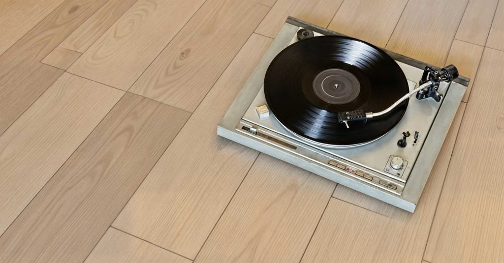 Platenspeler staat op luxe vinyl tegelvloer in moderne woonkamer