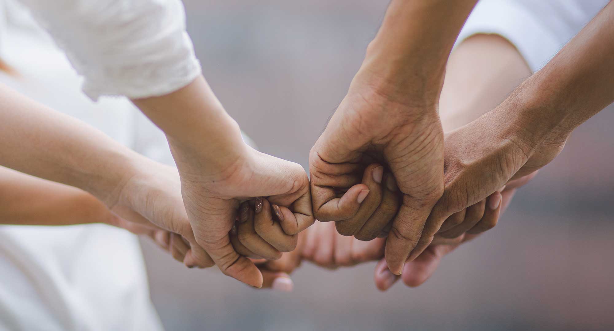 4 mensen die hun vuisten tegen elkaar houden. 1 team